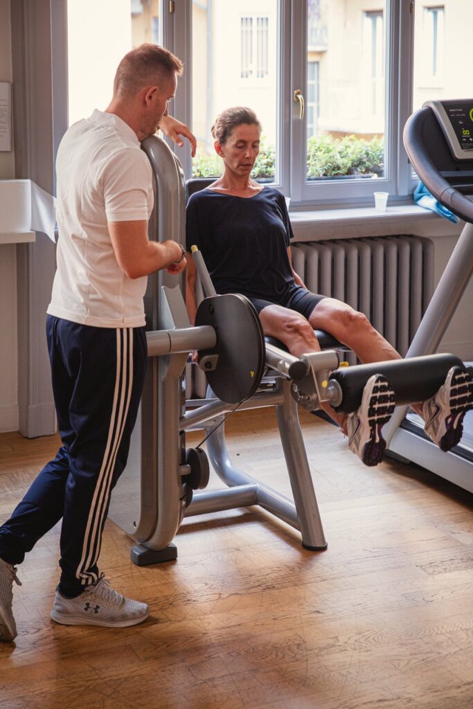 Il personal trainer corregge la posizione di una cliente durante l’esercizio