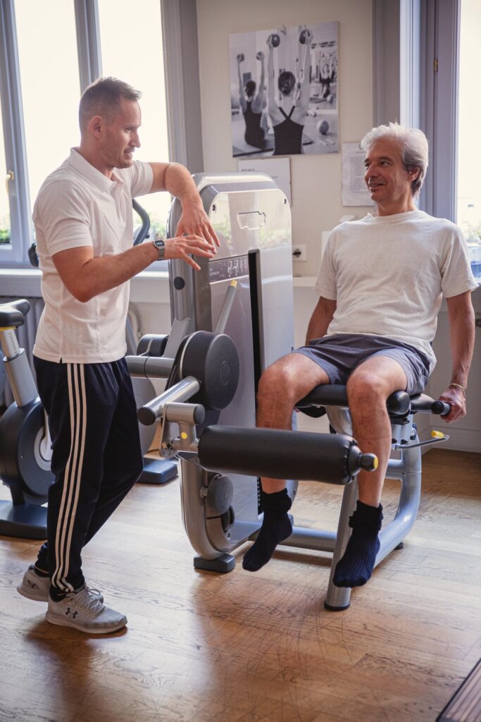 Il personal trainer spiega un esercizio a un cliente al Centro Onze di Milano