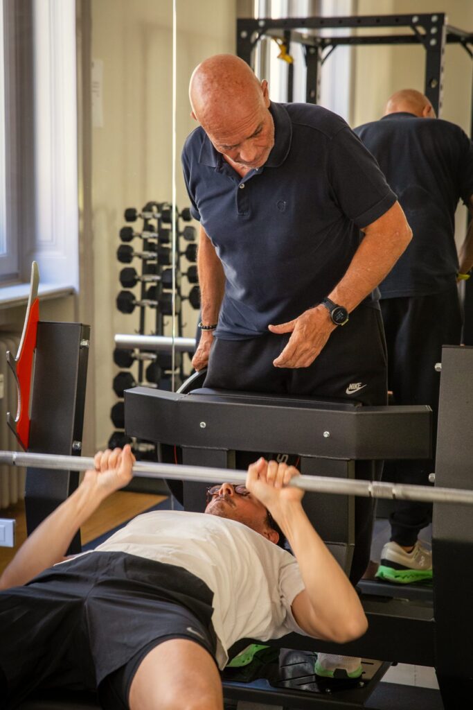 Istruttore che segue un cliente alla panca nella sala Strength & Conditioning di Centro Onze